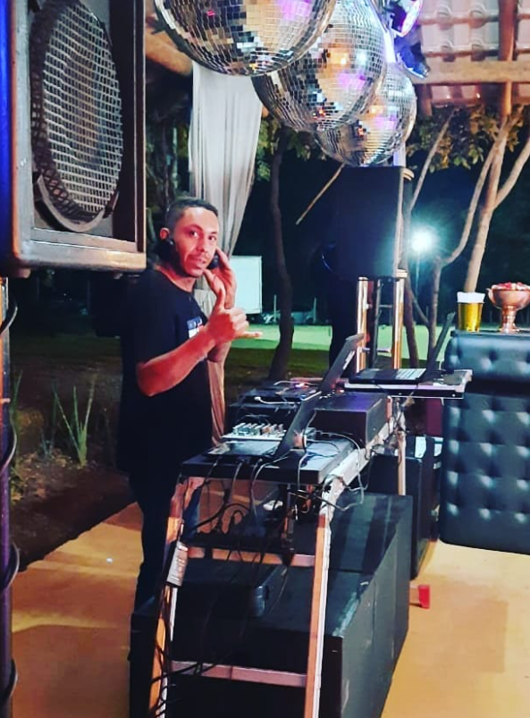 DJ Carlos Felpiz com estrutura de som e iluminação em evento
